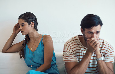 Buy stock photo Shot of a young couple having an argument while sitting on their couch at home