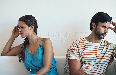 Buy stock photo Shot of a young couple having an argument while sitting on their couch at home