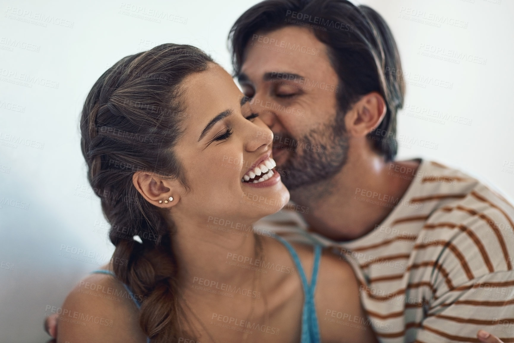 Buy stock photo Happy, couple and kiss in home with love for relationship commitment, affection and compassion with care. Man, woman and embrace together in house with soul connection, joy and romance with bonding.