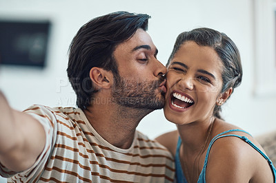 Buy stock photo Portrait of a happy young couple posing for a selfie on their couch at home
