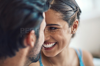 Buy stock photo Shot of an affectionate young couple bonding on their couch at home
