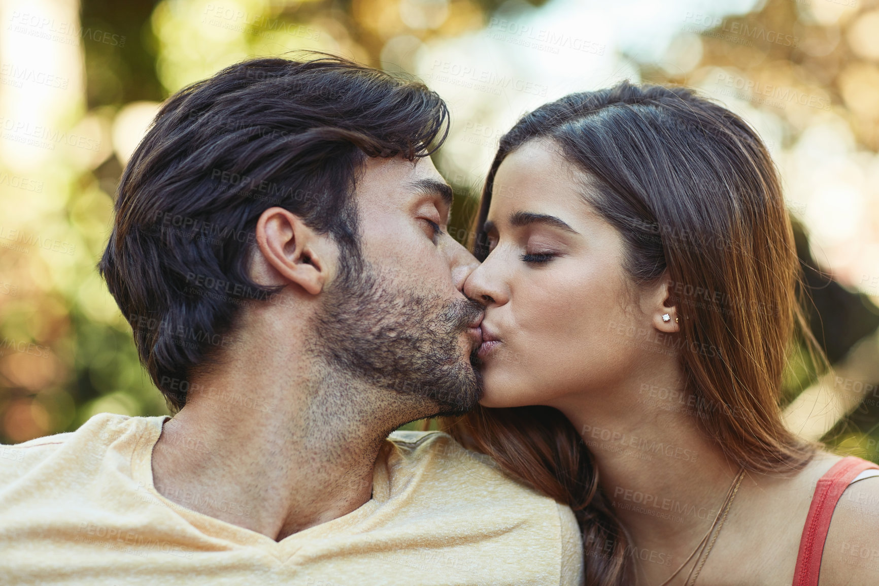 Buy stock photo Outdoor, couple and kiss in garden or park for bonding, love and affection in Spain. People, relationship and support with care as lovers on break to relax, rest and embrace for date or romance