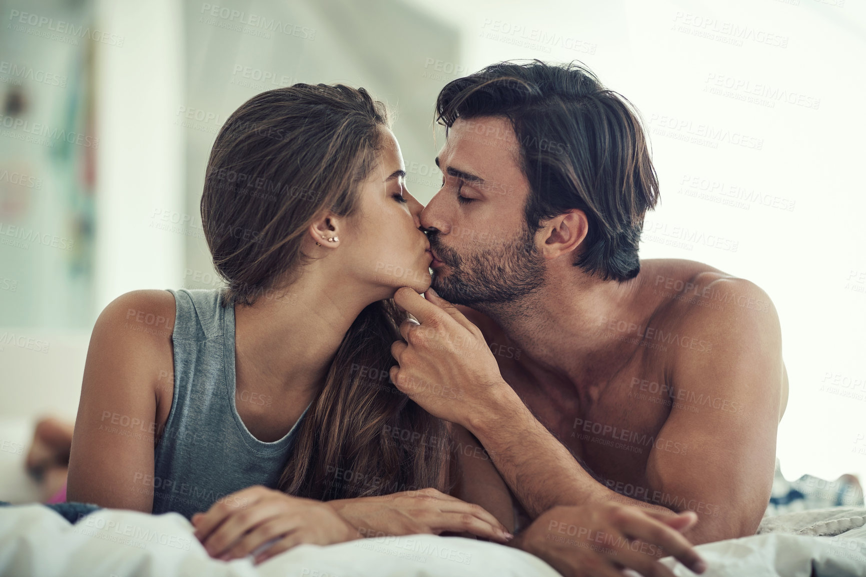 Buy stock photo Love, couple and kiss in bedroom in home for care, romance and bonding together to relax. Morning, man and intimate woman in bed for healthy relationship, connection or support with passion in house