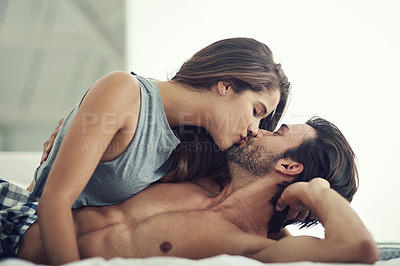 Buy stock photo Cropped shot of an affectionate young couple being intimate in their bed