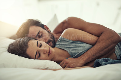 Buy stock photo Cropped shot of an affectionate young couple sleeping in their bed