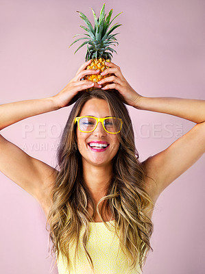 Buy stock photo Studio shot of a young woman holding a pineapple against a pink background