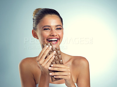 Buy stock photo Studio, laugh and woman with chocolate for eating, snack and dessert for female person. Thinking, happy girl and sweets for mood enhance, candy and cognitive benefits for memory by gray background