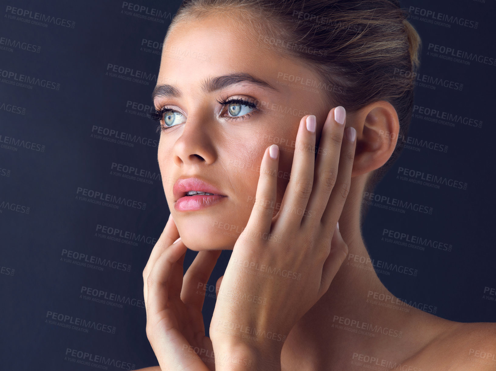 Buy stock photo Studio shot of an attractive young woman posing and touches her face with both hands