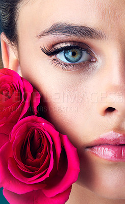 Buy stock photo Studio shot of an attractive young woman posing next to a couple of beautiful pink roses