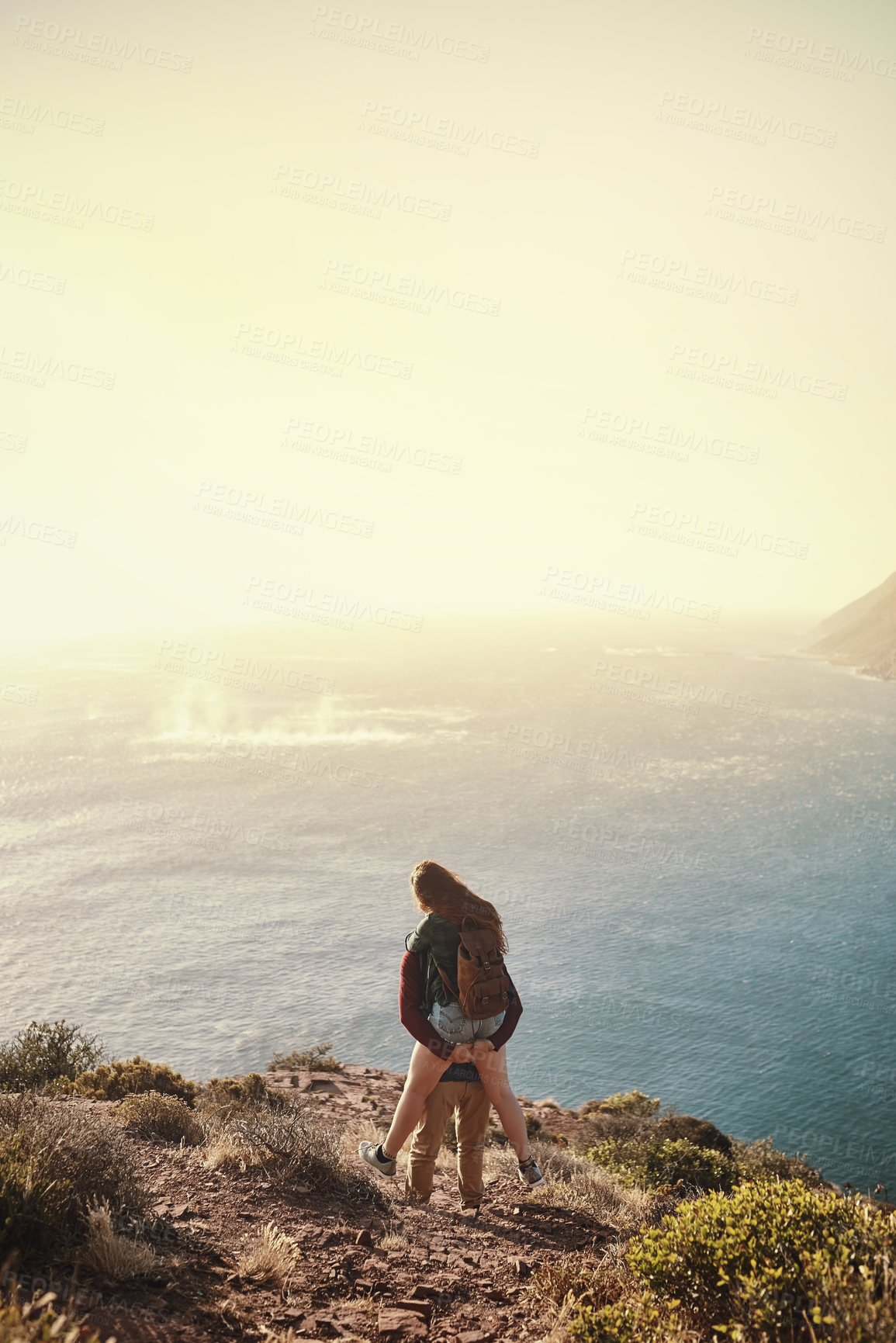 Buy stock photo Rearview shot of a young man piggybacking his girlfriend during their hike in the mountains