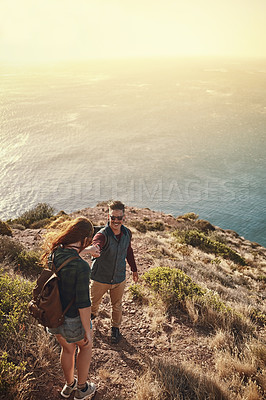 Buy stock photo Hiking, man and woman on mountain holding hands for support, help and adventure or travel. Tourists, couple and happy in nature or countryside for vacation together with sunrise in summer for morning