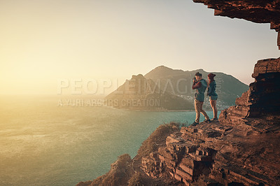 Buy stock photo Full length shot of a young man taking picture of the view while hiking with his girlfriend