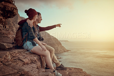 Buy stock photo Full length shot of an affectionate young couple taking in the view from a mountaintop