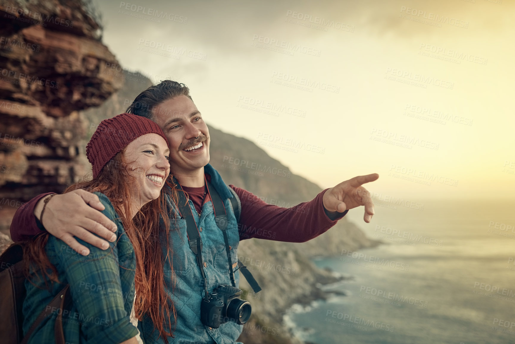 Buy stock photo Cropped shot of an affectionate young couple taking in the view from a mountaintop