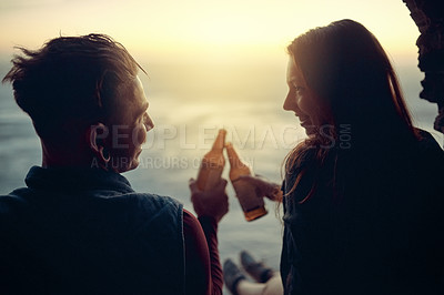 Buy stock photo Cropped shot of an affectionate young couple toasting with beers atop a mountain