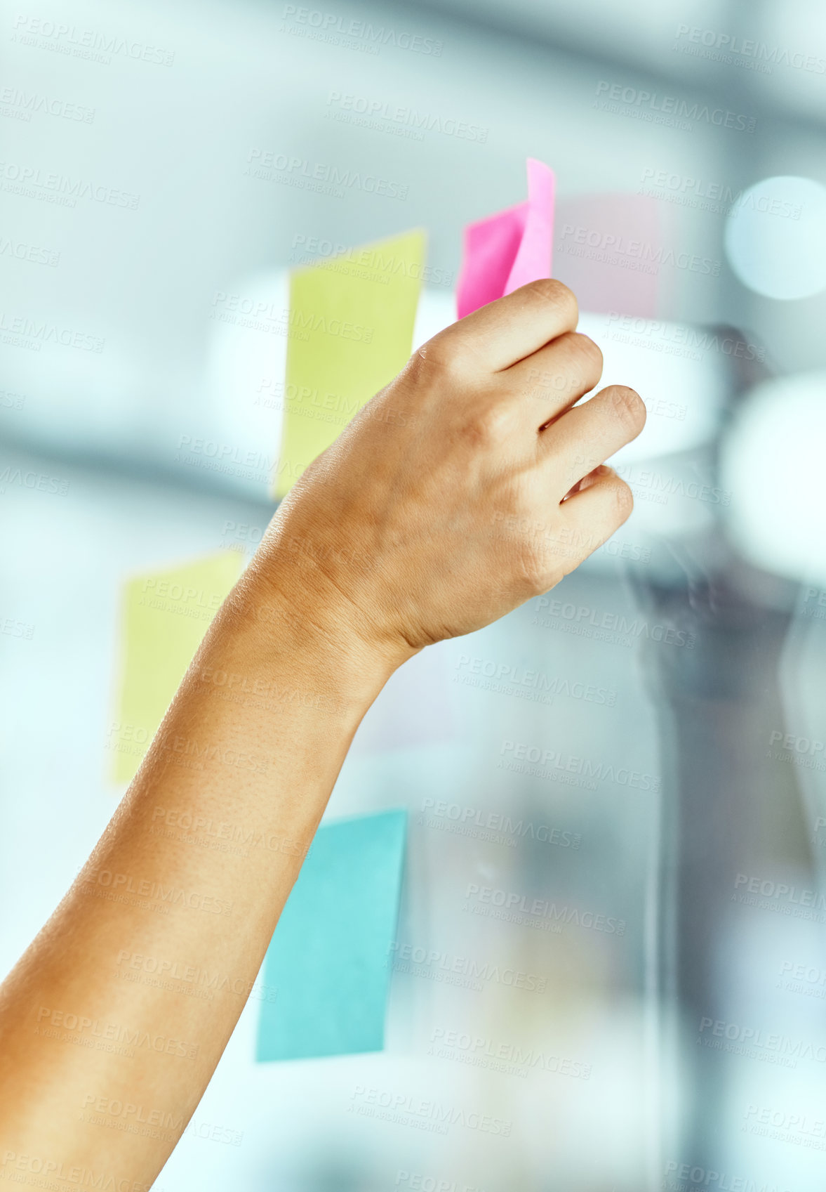 Buy stock photo Cropped shot of a woman pasting notes on glass during a brainstorming session at work