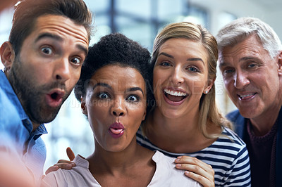 Buy stock photo Shot of a group of colleagues taking a fun selfie together in a modern office