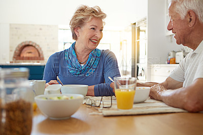 Buy stock photo Senior, couple and happy with eating at breakfast in dining room for nutrition, healthy meal and retirement. Elderly, people and smile in home with conversation, relax or morning routine in apartment