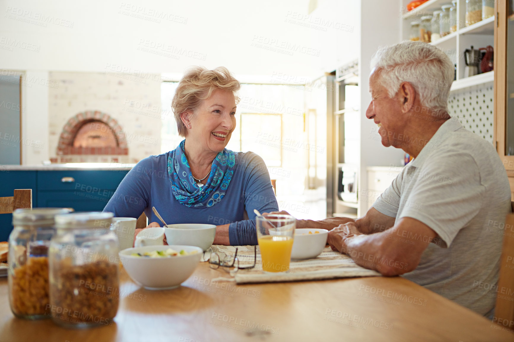 Buy stock photo Elderly, couple and happy with eating at breakfast in dining room for nutrition, healthy meal and retirement. Senior, people and smile in home with conversation, relax or morning routine in apartment