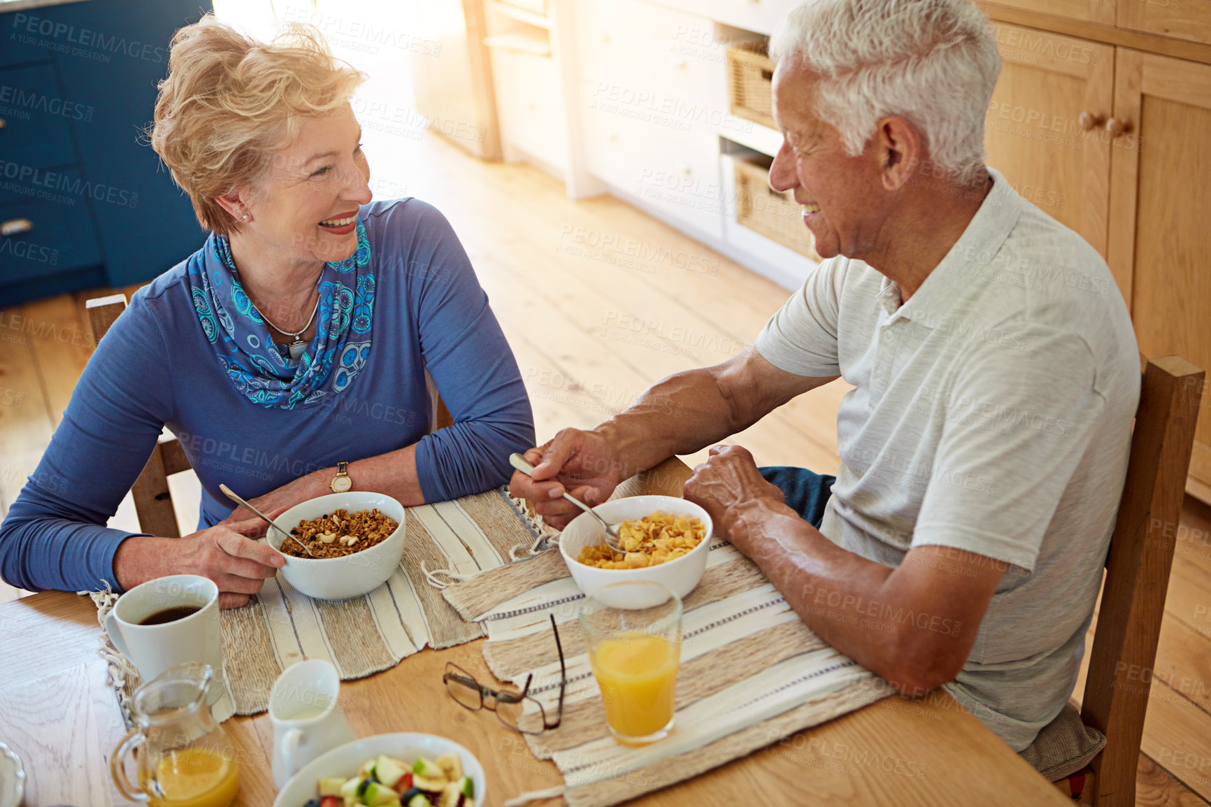 Buy stock photo Senior, couple and talking with eating at breakfast in dining room for nutrition, healthy meal and retirement. Elderly, people and smile in home with conversation, relax or morning routine from above