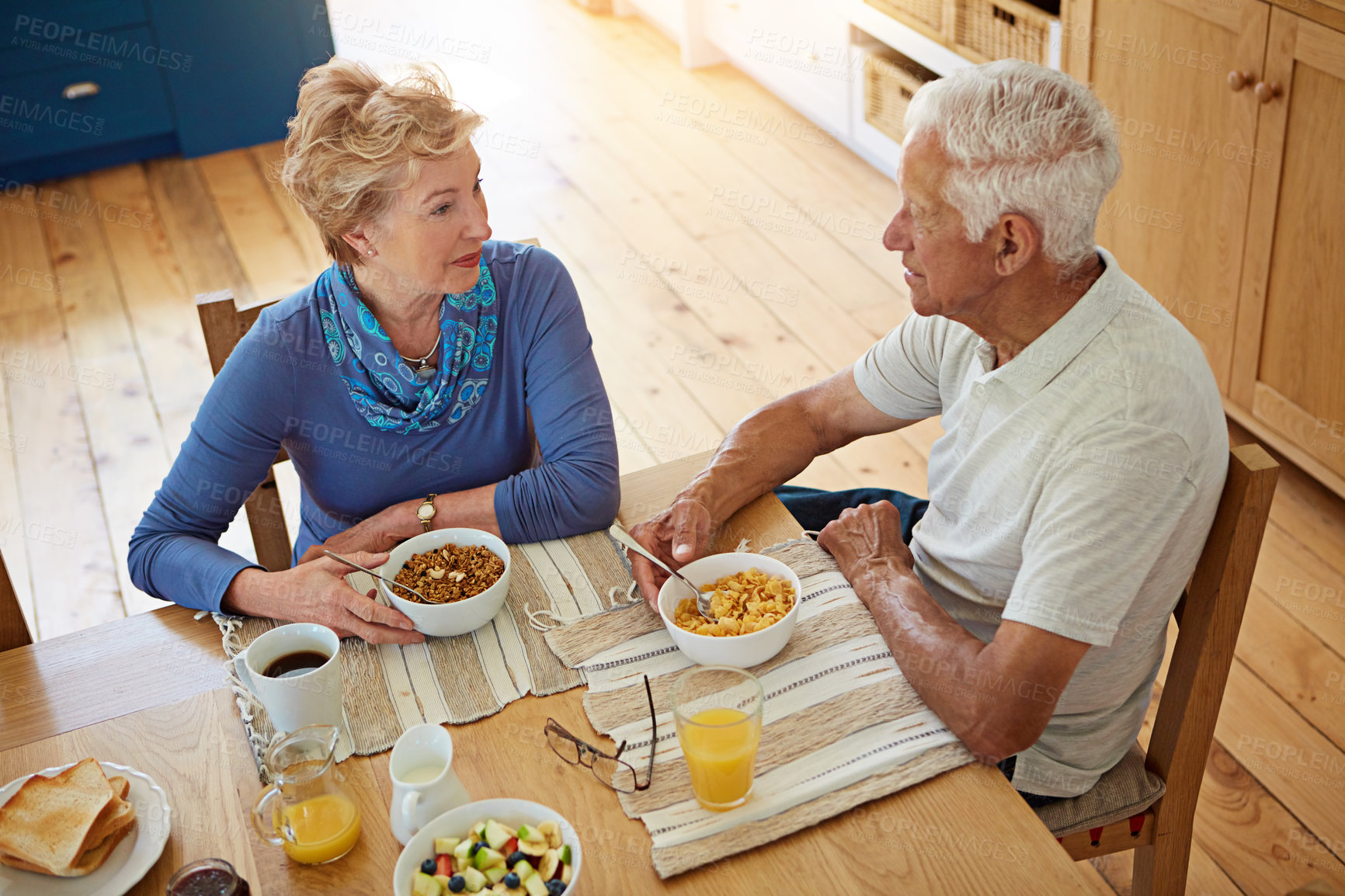 Buy stock photo Elderly, couple or talking with eating at breakfast in dining room for nutrition, healthy meal or retirement. Senior, people or porridge in home with conversation, relax or morning routine from above