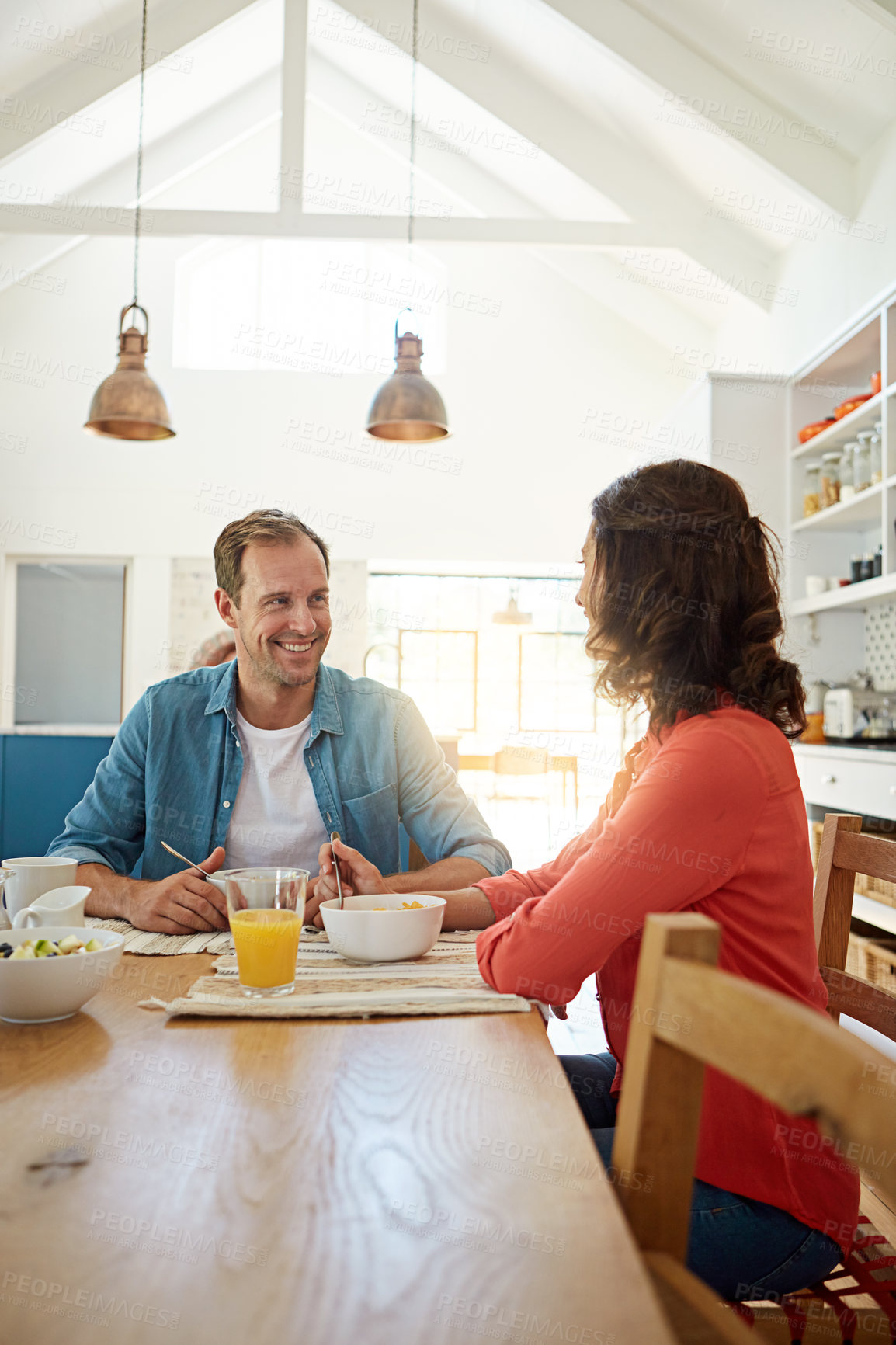 Buy stock photo Shot of a happy married couple enjoying breakfast in their kitchen at home