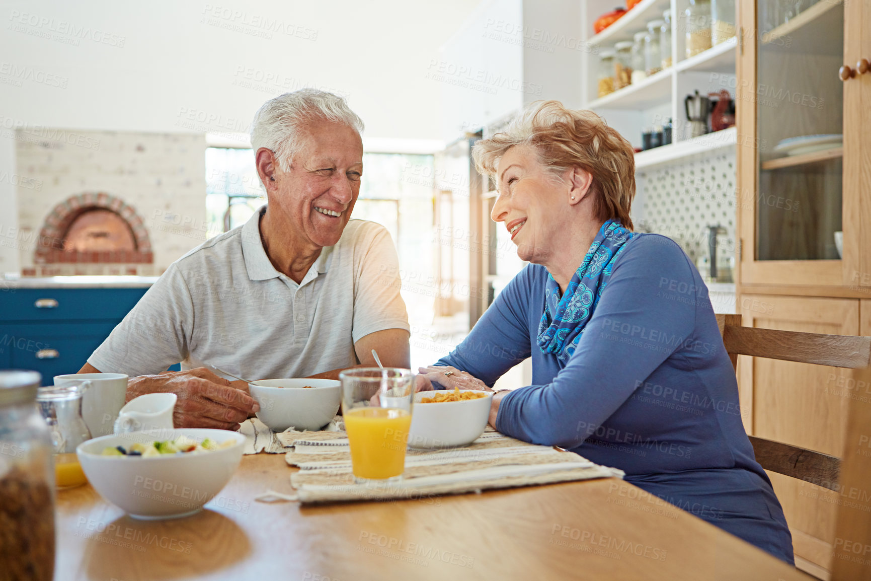 Buy stock photo Shot of a happy mature couple having breakfast together in their kitchen at home