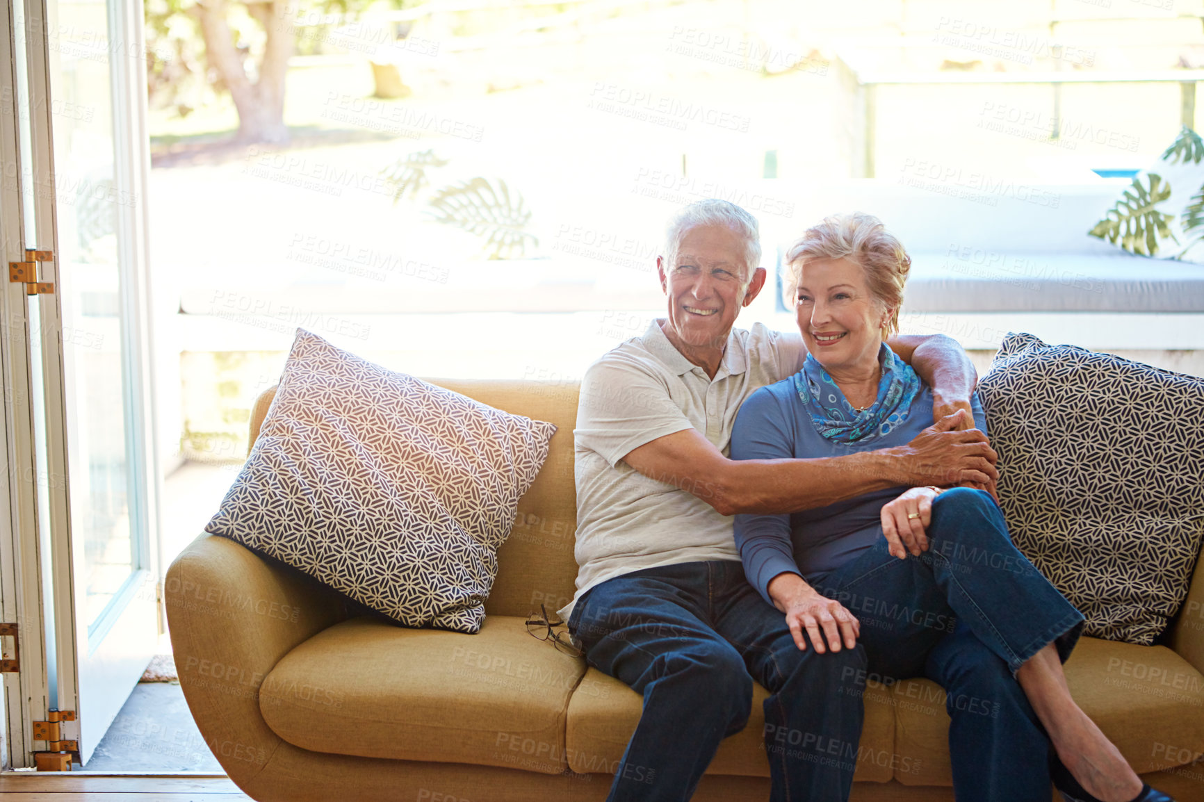 Buy stock photo Shot of an affectionate senior couple cuddling on a sofa at home