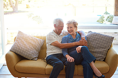 Buy stock photo Shot of an affectionate senior couple cuddling on a sofa at home