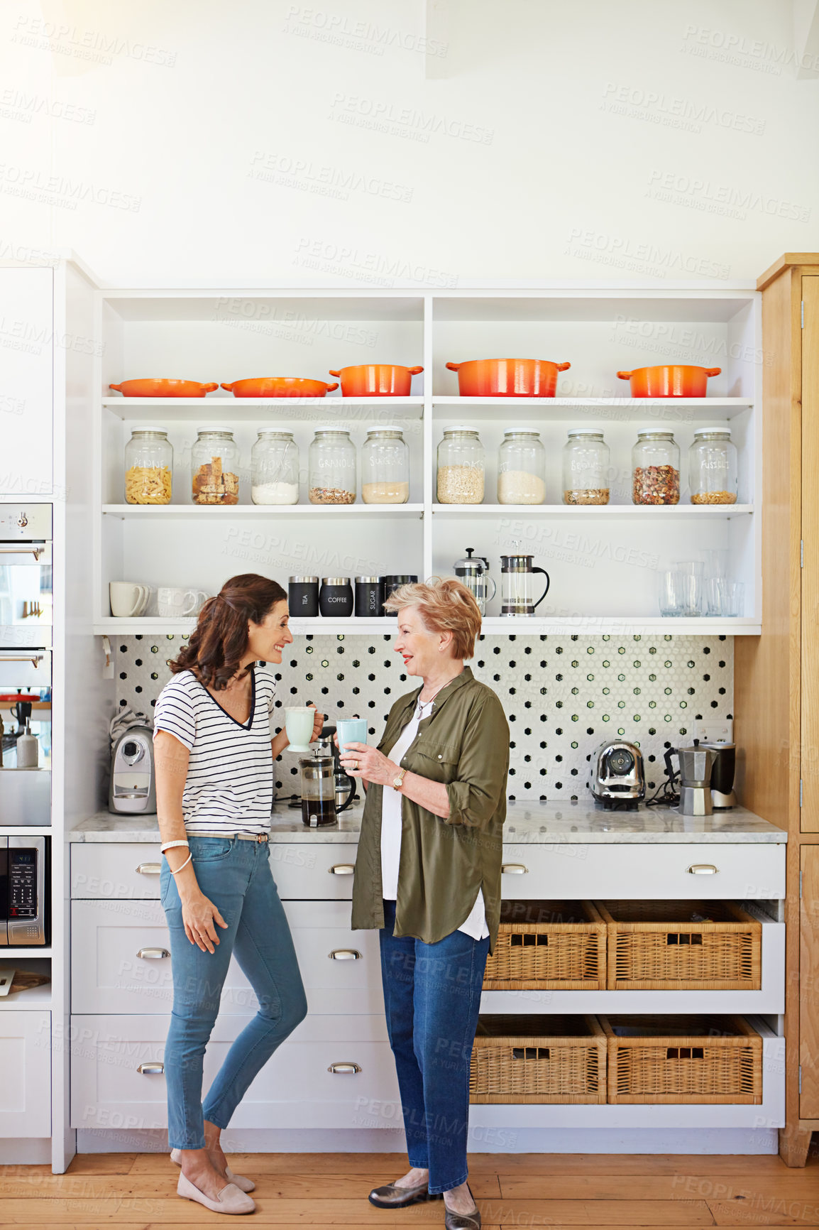 Buy stock photo Shot of a woman and her elderly mother catching up over coffee in the kitchen