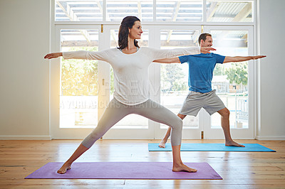 Buy stock photo Full length shot of a mature couple practicing yoga in their home