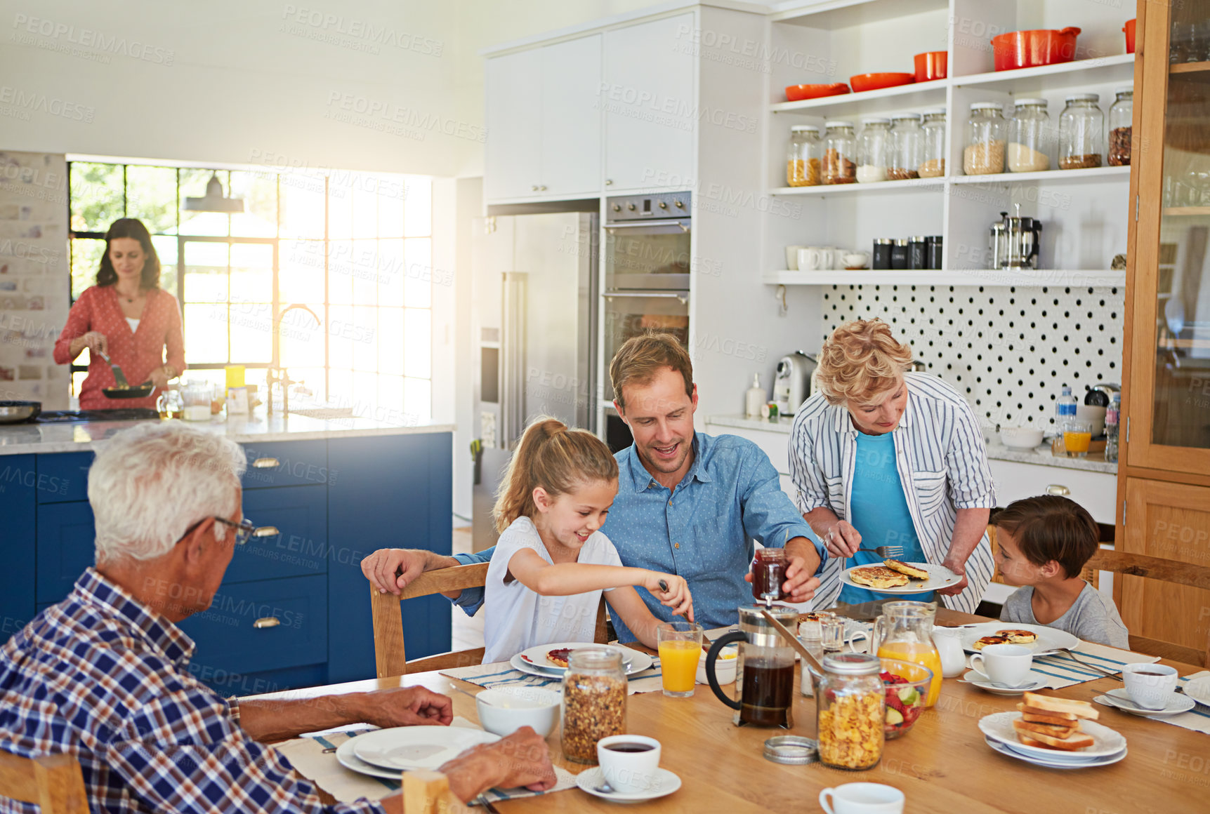 Buy stock photo Cropped shot of a multi generational family enjoying breakfast together at home