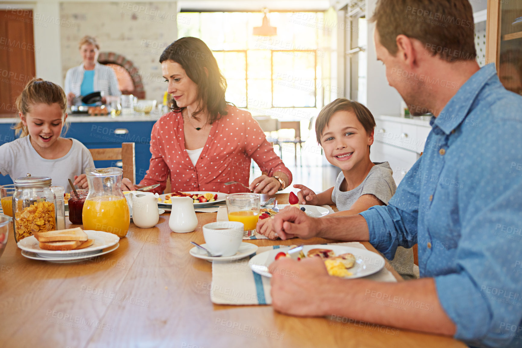 Buy stock photo Food, breakfast and love with a family in the dining room of their home together for nutrition. Portrait of a boy with his parents and sister eating at a table in an apartment for morning bonding