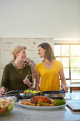 Buy stock photo Shot of a senior woman and her daughter cooking in the kitchen