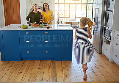 Buy stock photo Shot of a little girl dancing while her mother and grandmother cooks in the background