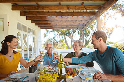 Buy stock photo Shot of a happy family toasting with wine during a family lunch outdoors