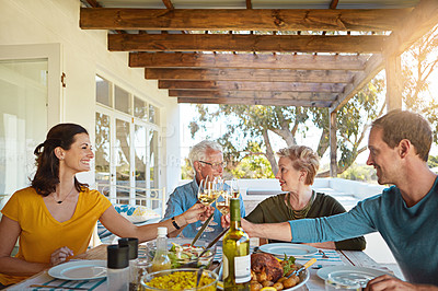 Buy stock photo Shot of a happy family toasting with wine during a family lunch outdoors