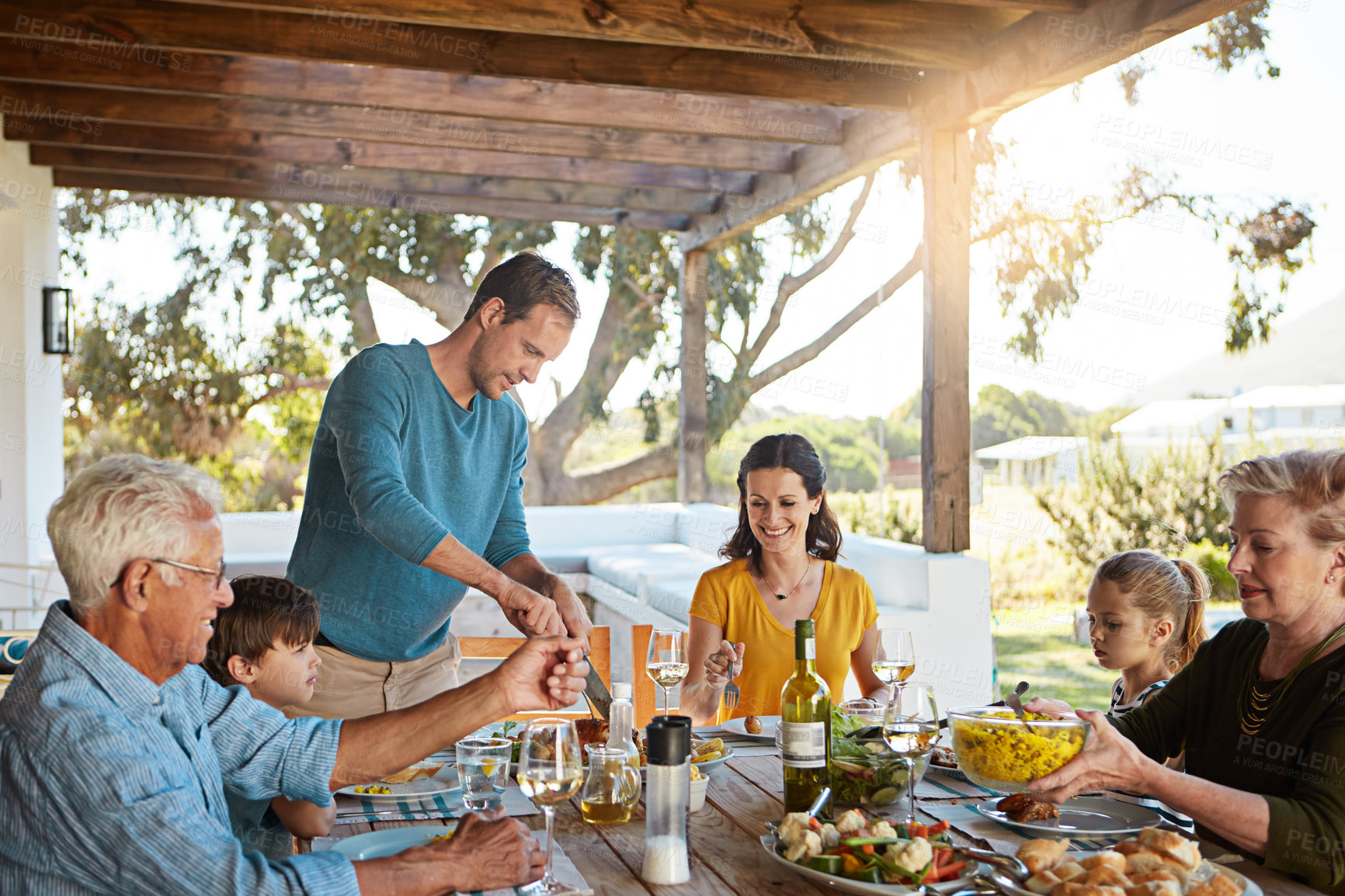 Buy stock photo Happy family, eating and lunch with food outdoor on patio with conversation, bonding or healthy meal in summer. Parents, grandparents and kids at dining table in backyard of home with love or talking