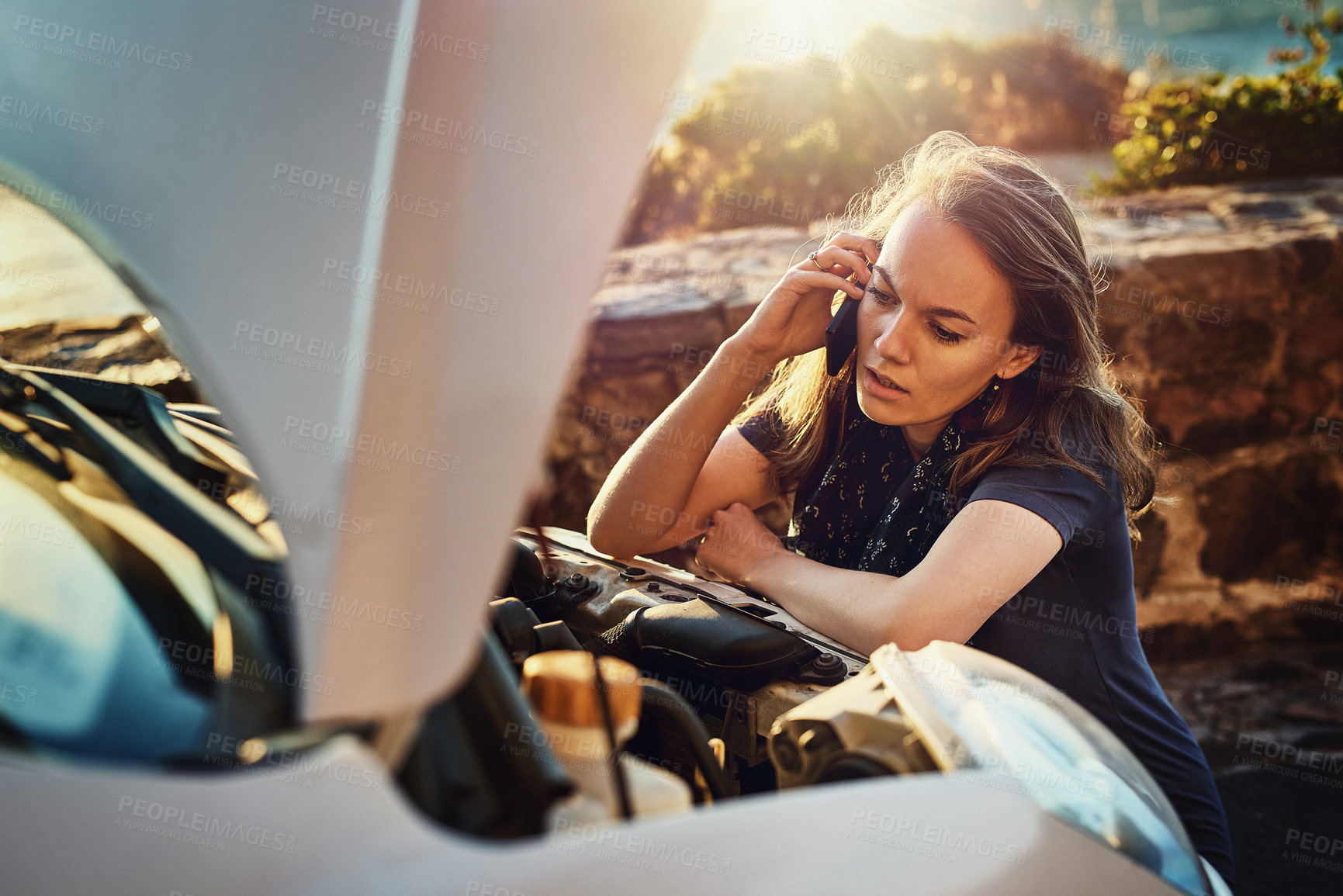 Buy stock photo Cropped shot of a young woman calling roadside assistance after breaking down