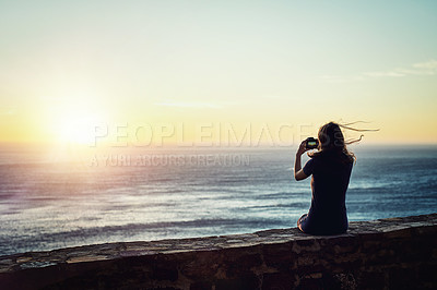 Buy stock photo Rearview shot of a young woman taking photos with her camera outdoors