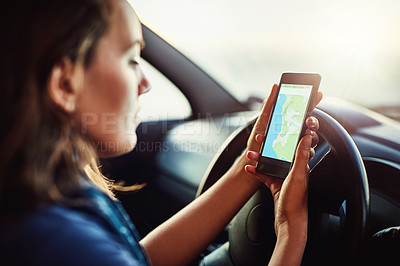 Buy stock photo Cropped shot of a young woman using her cellphone to find directions while driving