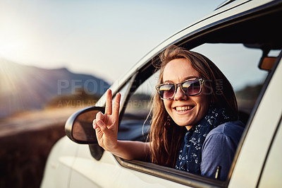Buy stock photo Portrait of a young woman showing a piece sign while sitting in her car