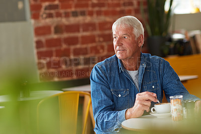 Buy stock photo Shot of a relaxed senior man enjoying a cup of coffee in a coffee shop
