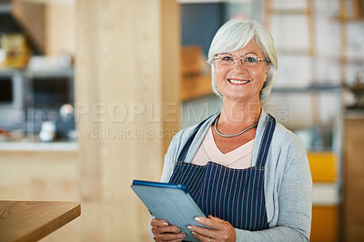 Buy stock photo Portrait of a happy senior business owner using a tablet in her coffee shop