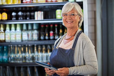 Buy stock photo Portrait of a happy senior business owner using a tablet in her coffee shop