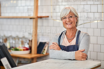 Buy stock photo Portrait of a happy senior business owner posing at the counter in her coffee shop