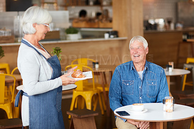 Buy stock photo Shot of a happy senior business owner serving a customer in her coffee shop