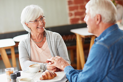 Buy stock photo Shot of a happy senior couple relaxing with a cup of coffee in a coffee shop