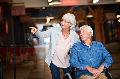Buy stock photo Shot of a happy senior couple bonding at the mall on the weekend