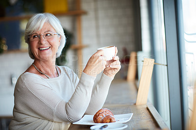 Buy stock photo Cropped shot of a senior woman enjoying a coffee in her local coffee shop